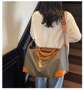 Gros plan d'un sac de voyage vert armée porté en bandoulière sur un escalier en bois.