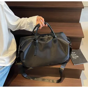 Sac de voyage noir haut de gamme avec bandoulière sur un élégant escalier en bois