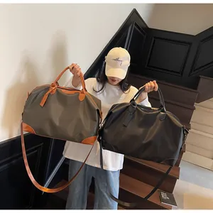 Mannequin présentant deux grands sacs de voyage en gris et noir sur un escalier d'intérieur