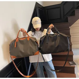 Grands sacs de voyage élégants en gris et noir présentés par un mannequin