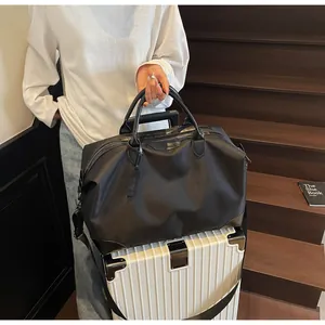 Gros plan d'un sac de voyage noir posé sur une valise dans un cadre de vie