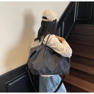 Un mannequin portant un grand sac de voyage en nylon noir sur son épaule à l'intérieur