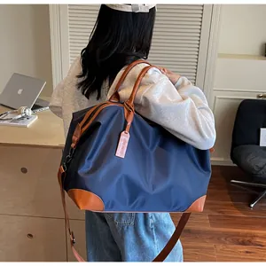 Vue de dos d'une personne portant un grand sac de voyage en nylon bleu marine et marron
