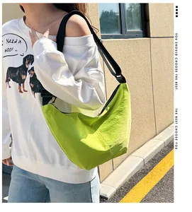 Primer plano de un bolso de media luna verde lima llevado por una modelo en un entorno urbano