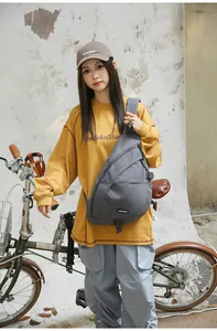 Graue Retro Streetstyle Umhängetasche für Damen und Herren an einer jungen Frau