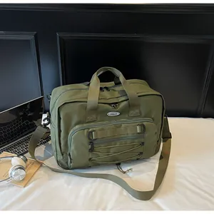 Detail showing the tactical webbing and bungee cord design on the army green travel bag.