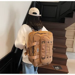 Large brown tactical travel backpack shown on a model on stairs for scale and style