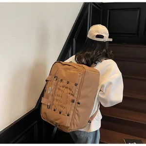 Detail of a large brown functional travel backpack shown from the back on a model