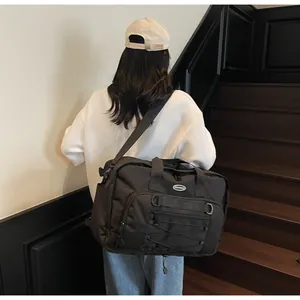 Large black capacity techwear messenger bag for travel and sport worn by a model