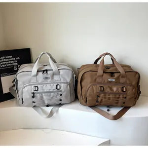 Pair of grey and brown large-capacity travel duffel bags displayed on a white stand