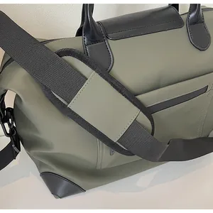 Close-up detail of olive green large capacity travel bag with black shoulder strap