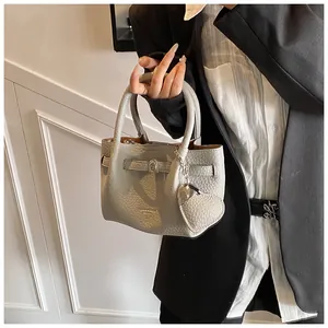 Detailed view of grey lychee grain pebbled leather bucket bag with silver heart charm
