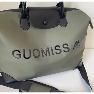 Detail shot of an olive green large travel bag featuring black GUOMISS letter printing