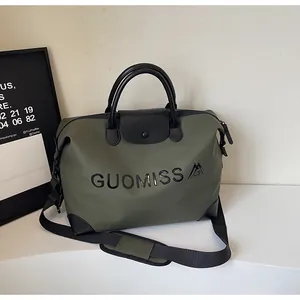 High-quality close-up of large olive green travel bag with GUOMISS letter print