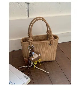 Stilvolle hellbraune Eimertasche aus gewebtem Kunstleder mit süßem Bärenanhänger-Detail