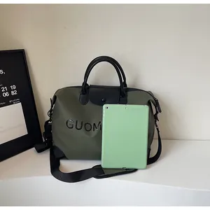 Large capacity olive green travel bag with letter print shown with a tablet for scale