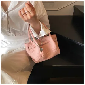 Close-up detail of a small pink pebbled leather handbag with elegant silver hardware