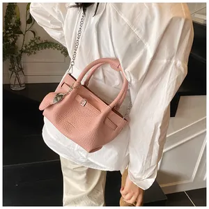 Pink lychee texture bucket bag with silver chain strap and top handle detail