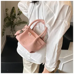 Detailed shot of a pink lychee pattern bucket bag featuring a silver chain strap