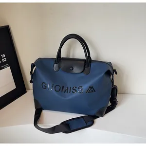 Detailed perspective view of large capacity blue travel bag with GUOMISS logo print