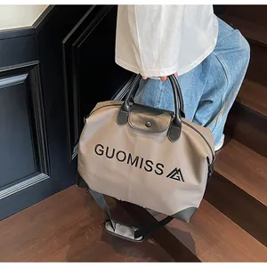 Detailed view of the GUOMISS letter print travel bag with leather handles
