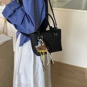 Stilvolle schwarze gewebte Schultertasche für Damen mit einem süßen Bären-Anhänger