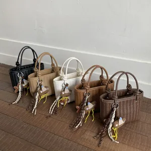 Trendige gewebte Eimerhandtaschen in fünf Farben mit süßem Bärenanhänger für Damen.