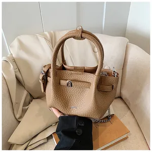 Detailed view of lychee pattern textured leather bucket bag with silver hardware