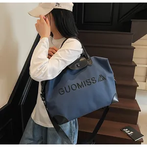 Side view of navy blue large capacity travel bag with black leather accents and GUOMISS lettering