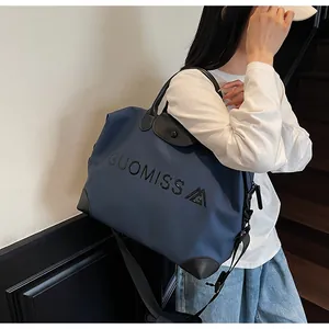 Stylish large capacity blue travel bag with black leather accents shown on a model
