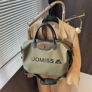 Olive green large capacity travel duffle bag with logo, displayed on a clothes rack
