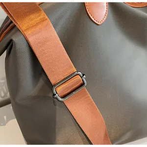 Vue détaillée du tissu en nylon et de la boucle de sangle réglable du sac de voyage.
