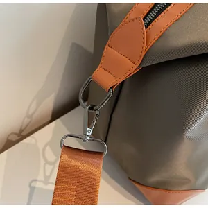 Gros plan sur la quincaillerie métallique et la sangle tissée d'un sac de voyage.