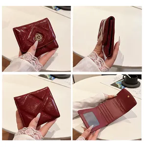 Detailed views of a burgundy quilted short wallet for women with gold clover buckle closure