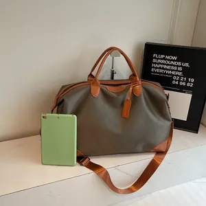 Grand sac de voyage en toile kaki avec poignées en cuir marron et une bandoulière