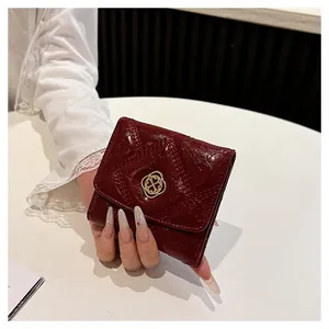 Detailed view of wine red quilted short wallet featuring a decorative gold flower buckle