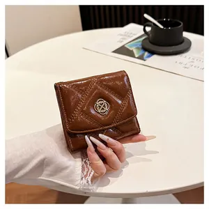 Macro view of a brown quilted faux-leather folding wallet featuring a golden logo