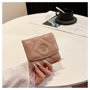 Elegant nude quilted short wallet for women with gold floral clasp held in hand