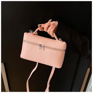 Vista detallada de un bolso de mano de cuero PU rosa con cremallera plateada elegante