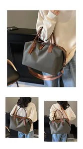 Detailed view of olive green nylon travel duffel bag with brown leather straps