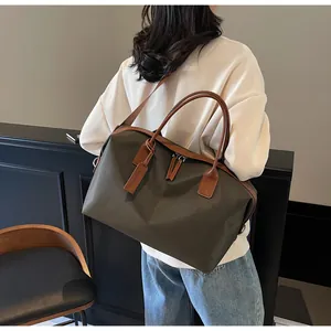 Olive green large capacity travel bag worn on shoulder in a lifestyle setting