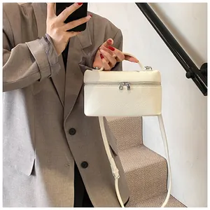Elegante bolso de mano blanco de cuero PU texturizado con una americana gris