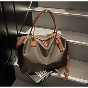Close-up of olive green large capacity travel duffle bag with brown leather handles