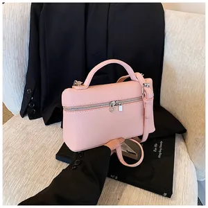 Detalle de un bolso de mano rosa en cuero PU granulado con cremallera doble y asa