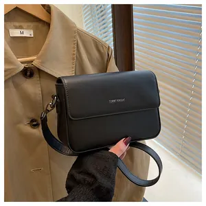 Close-up of minimalist black square crossbody bag with Tommy Knight logo