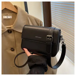 Close-up view of a minimalist black vintage small square crossbody bag for women.