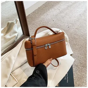 Detalle de un bolso de mano de cuero PU marrón con doble cremallera y bandolera