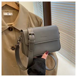 Macro view of the grey leather texture and metal buckle on the vintage square bag