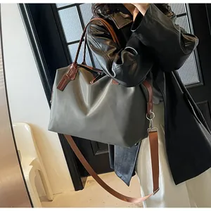 Large capacity grey nylon travel bag with brown shoulder strap for gym or commuting