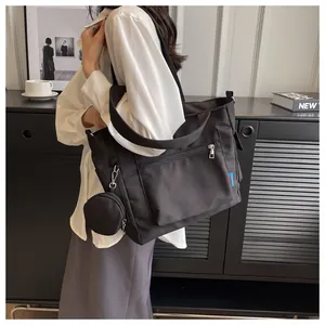 Detail of black large capacity canvas tote bag worn by a model in a casual setting